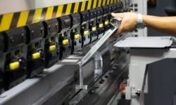 The technician operator use hydraulic bending machine. The sheet metal manufacturing process.